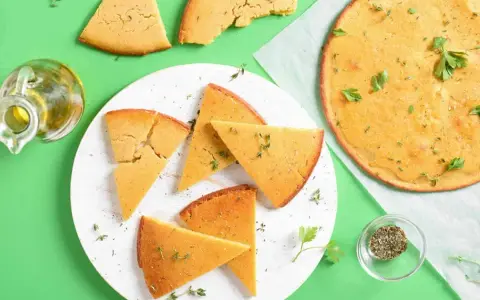 Une délicieuse socca coupée en parts, garnie d'herbes fraîches. Parfait pour une recette facile et savoureuse.
