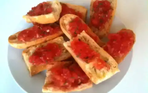 Des tranches de pain grillé garnies de tomates fraîches et d'herbes. Un délice simple et savoureux, parfait pour un apéritif.