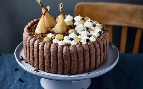 Charlotte poire chocolat, un gâteau élégant avec des poires pochées dorées, de la crème fouettée et des éclats de chocolat.