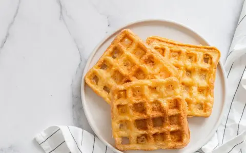 Trois gaufres au sarrasin dorées et croustillantes sur une assiette blanche, prêtes à être dégustées.
