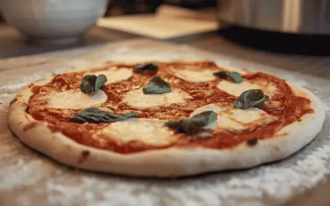 Une délicieuse pizza Margherita, avec sa pâte à pizza maison, prête à être dégustée. Un vrai délice pour les amateurs de pain et de bonnes choses.