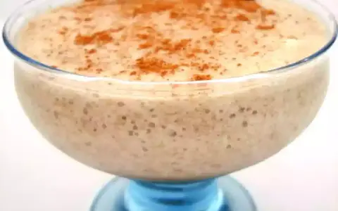 Un déliceux mousse banane crémeuse, saupoudrée de cannelle, servie dans un joli bol en verre bleu.