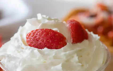 Chantilly aérienne garnie de fraises fraîches. Une invitation à découvrir comment faire de la chantilly maison pour un dessert parfait.