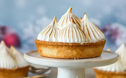 Tartelette dorée garnie d'une meringue italienne aérienne aux pointes caramélisées, comme des sommets enneigés.