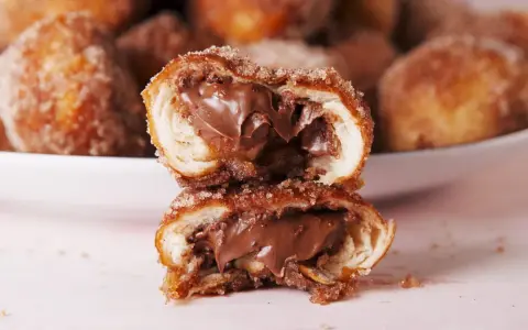 Bretzel au Nutella coupé en deux, révélant une garniture crémeuse au chocolat.