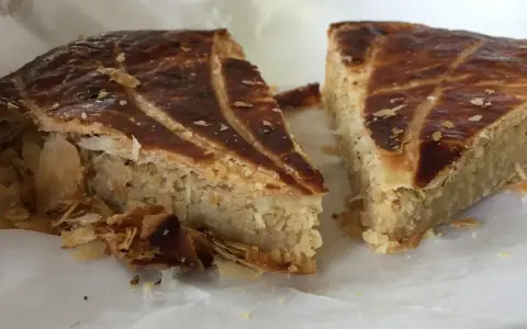 Deux parts de galette des rois coco, avec leur feuilletage doré et leur garniture généreuse, prêtes à être dégustées.