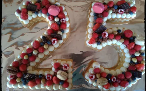 Gâteau chiffre 25 décoré de chantilly mascarpone, framboises, fraises, myrtilles, macarons et chocolat.