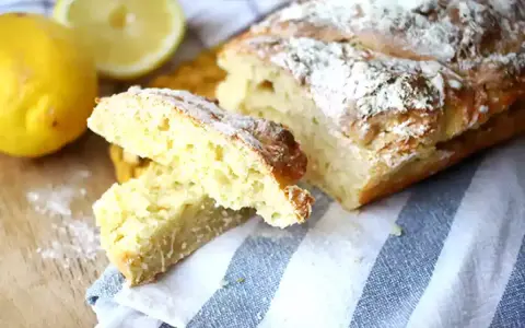 Pain de mie levure chimique, doré et saupoudré de farine, avec des citrons frais à côté.