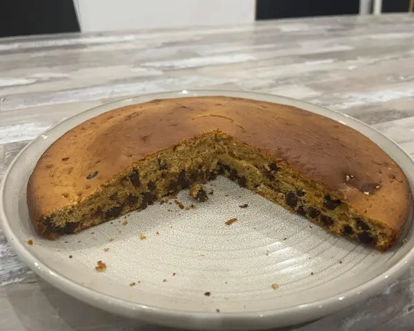Gâteau chocolat compote, moelleux et parsemé de pépites, prêt à être dégusté.