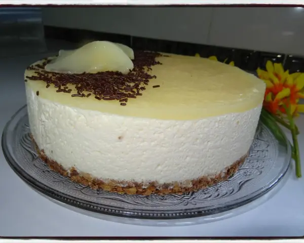 Délicieux bavarois poire, léger et aérien, sur une fine couche de biscuit croustillant, décoré de vermicelles au chocolat et de poires pochées.