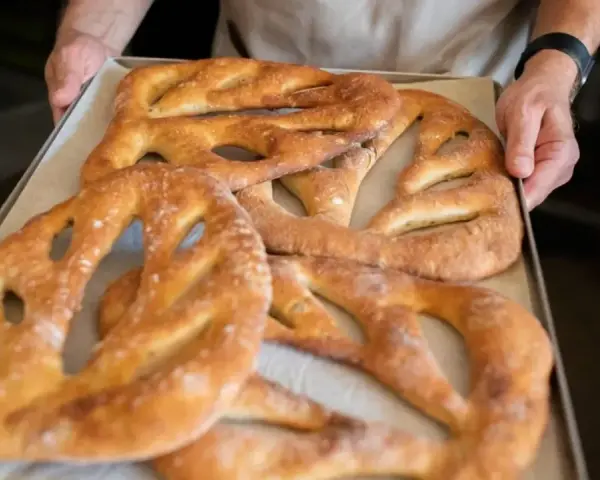 Une fougasse aux grattons feuilletée, dorée et croustillante, sort du four. Un délice à partager !