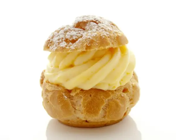 Un déliceux chou à la crème, saupoudré de sucre glace, avec une généreuse garniture de crème pâtissière onctueuse.