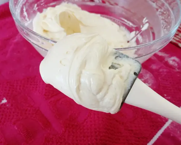 Crème onctueuse de mascarpone sur une spatule, prête pour une délicieuse recette.
