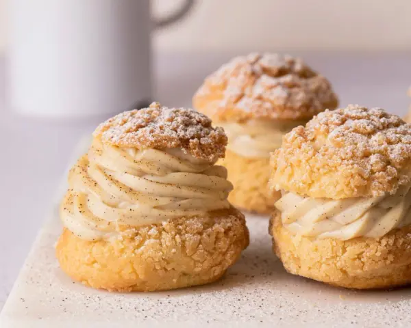 Trois délicieux choux garnis de crème pâtissière à la vanille, saupoudrés de sucre glace. Un vrai plaisir gourmand à base de pâte à choux.