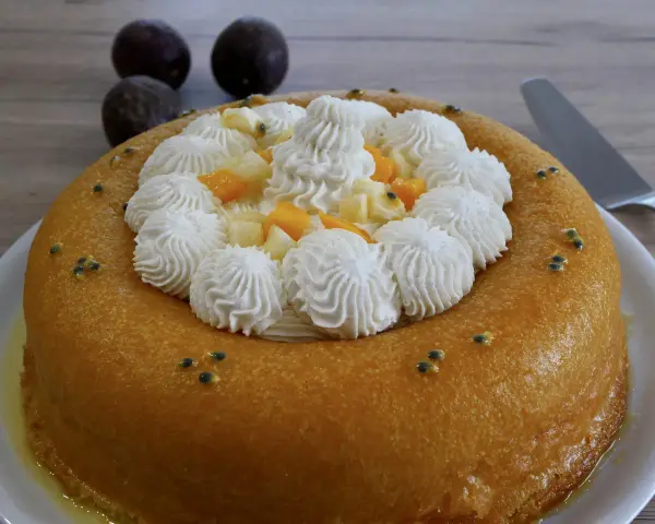 Un baba au rhum doré, garni de crème fouettée, fruits exotiques et graines de fruits de la passion. Un délice !