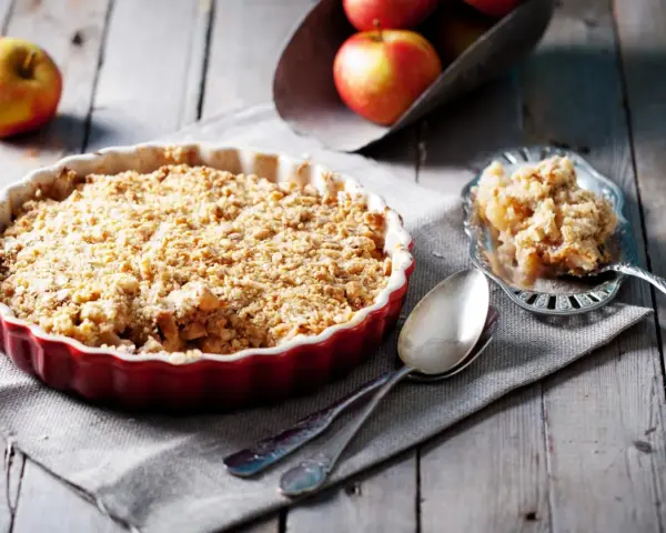 Un délicieux crumble pomme tout juste sorti du four, prêt à être dégusté. Des pommes fondantes sous une couche croustillante.