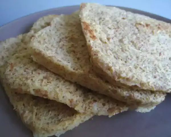 Tranches de pain au son d'avoine Dukan, légères et aérées, sur une assiette grise.