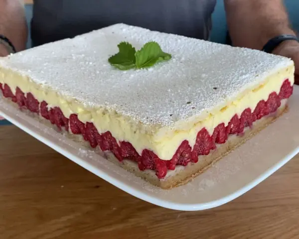 Un gâteau d'anniversaire facile et bluffant : une génoise légère, une crème onctueuse et des framboises fraîches, le tout saupoudré de sucre glace.