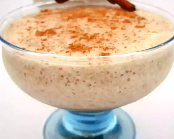 Un déliceux mousse banane crémeuse, saupoudrée de cannelle, servie dans un joli bol en verre bleu.