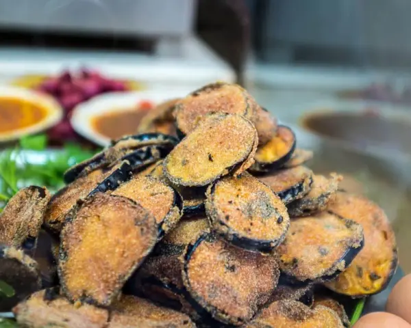 Un tas de beignets d'aubergine dorés et croustillants, prêts à être dégustés.