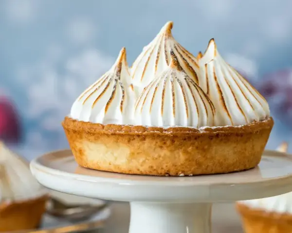 Tartelette dorée garnie d'une meringue italienne aérienne aux pointes caramélisées, comme des sommets enneigés.