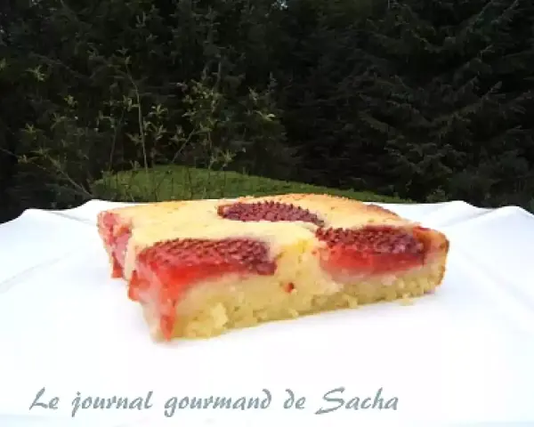 Un délicieux clafoutis aux fraises, tout juste sorti du four, sur une assiette blanche.