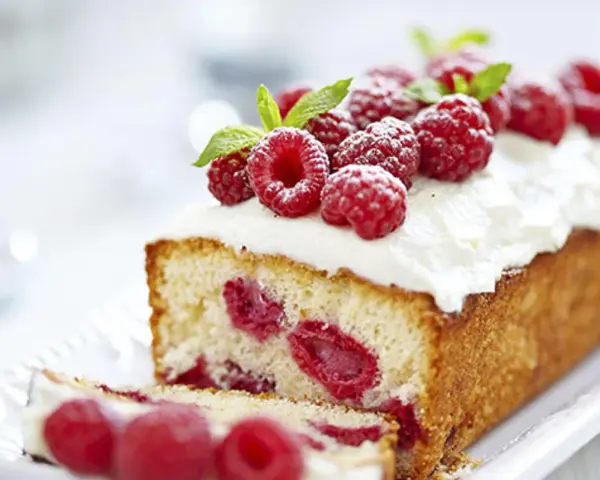 Un délicieux framboisier gateau, garni de framboises fraîches et de crème fouettée, prêt à être dégusté.