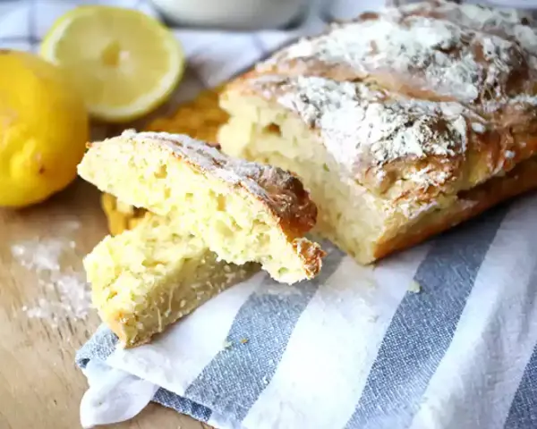 Pain de mie levure chimique, doré et saupoudré de farine, avec des citrons frais à côté.