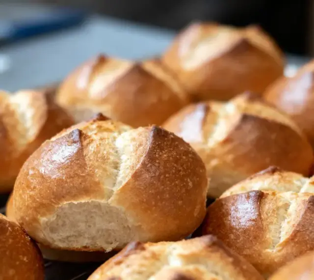 Une fournée de petits pains allemands dorés et croustillants, prêts à être dégustés.