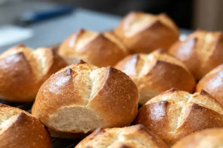 Une fournée de petits pains allemands dorés et croustillants, prêts à être dégustés.