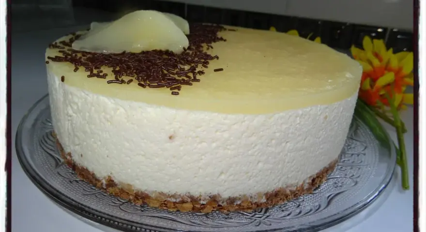 Délicieux bavarois poire, léger et aérien, sur une fine couche de biscuit croustillant, décoré de vermicelles au chocolat et de poires pochées.