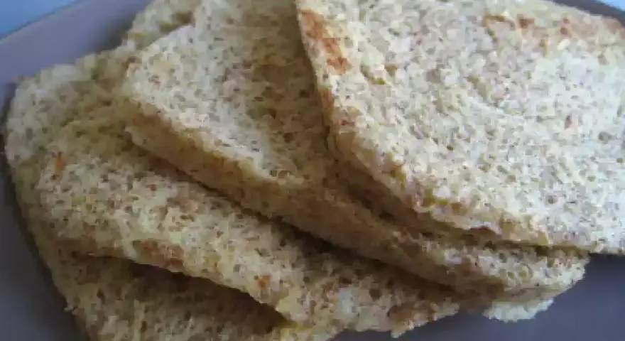 Tranches de pain au son d'avoine Dukan, légères et aérées, sur une assiette grise.