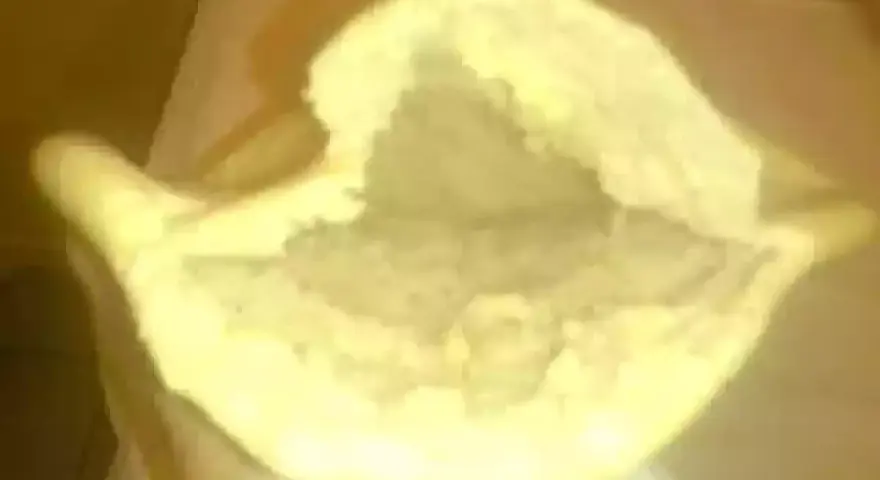 Une main tient un pain libanais ouvert, prêt à être garni. Sa texture moelleuse et sa poche invitent à la gourmandise.