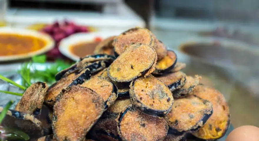 Un tas de beignets d'aubergine dorés et croustillants, prêts à être dégustés.