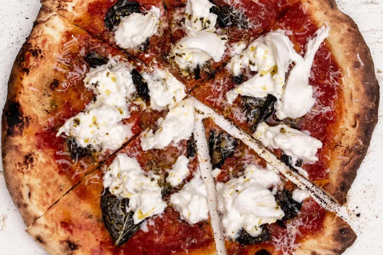 Une d&eacute;licieuse pizza burrata, garnie de sauce tomate, de fromage cr&eacute;meux et d'herbes fra&icirc;ches, pr&ecirc;te &agrave; &ecirc;tre d&eacute;gust&eacute;e.