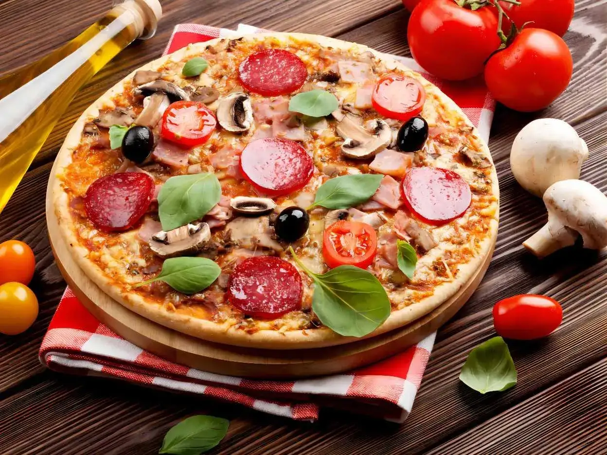 Une d&eacute;licieuse pizza reine garnie de salami, champignons, olives et basilic, pr&ecirc;te &agrave; &ecirc;tre d&eacute;gust&eacute;e.