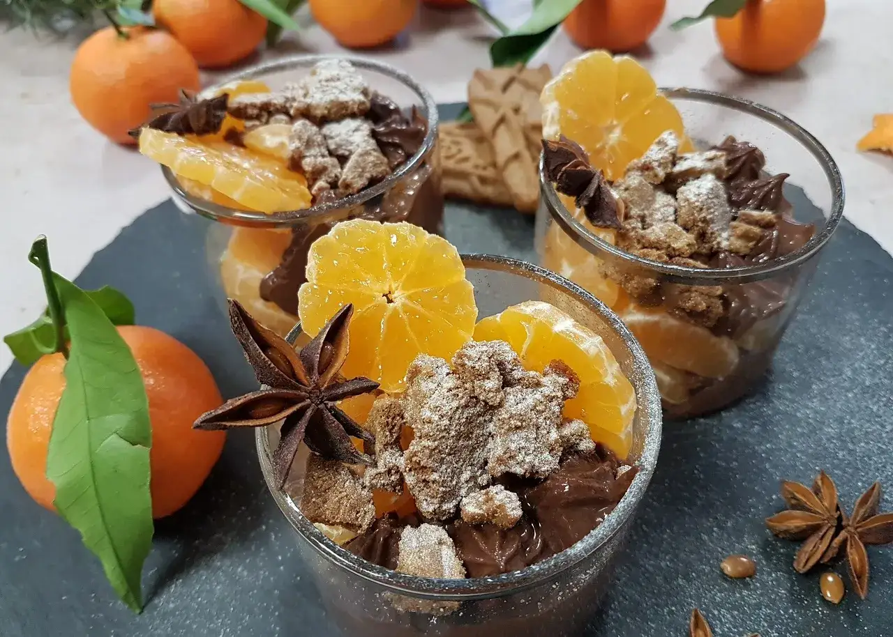 Trois verrines de recette mousse au chocolat onctueuse, garnies de cl&eacute;mentines, biscuits &eacute;miett&eacute;s et anis &eacute;toil&eacute;.