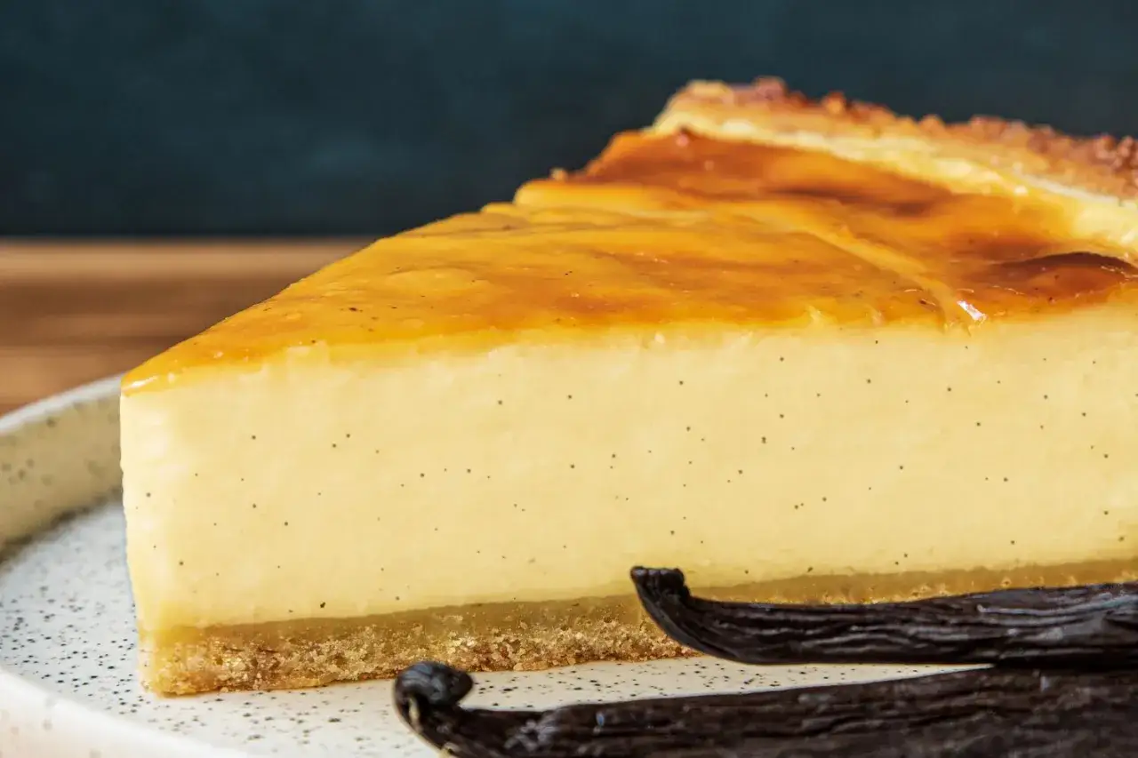 Tranche de flan onctueux &agrave; la vanille, parfait pour une recette flan sans p&acirc;te. La cro&ucirc;te dor&eacute;e et les gousses de vanille compl&egrave;tent ce d&eacute;lice.