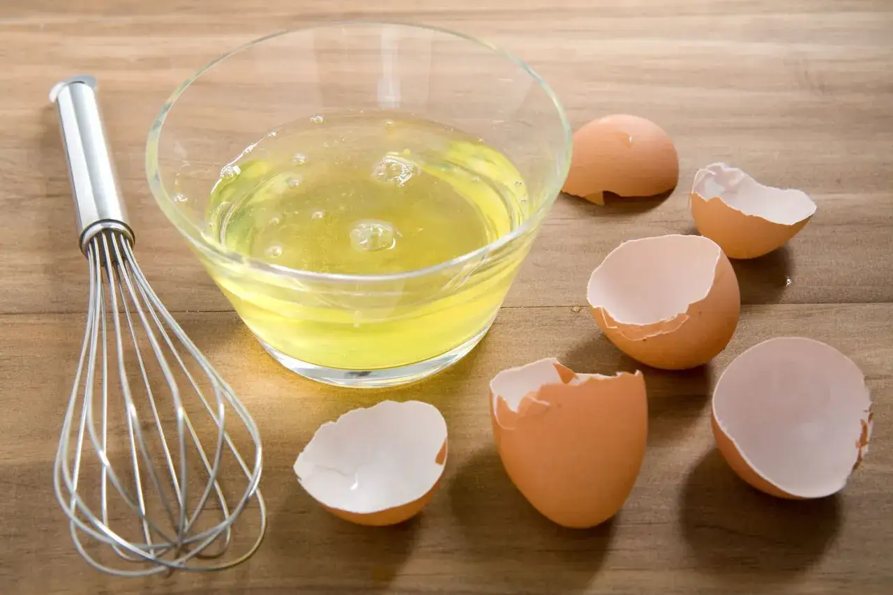 Un fouet et un bol de blancs d'&oelig;ufs, entour&eacute;s de coquilles vides. Parfait pour savoir que faire avec des blancs d'&oelig;ufs : meringues ou financiers !