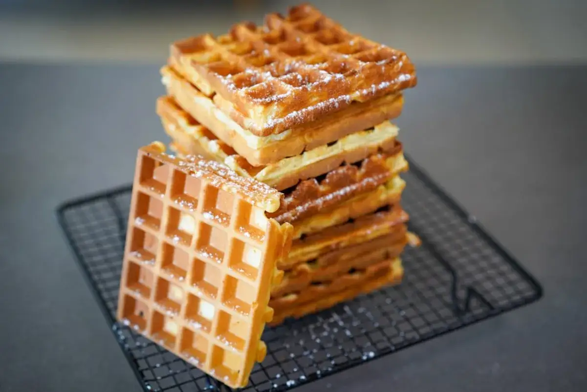 Pile de gaufres dor&eacute;es saupoudr&eacute;es de sucre glace, pr&ecirc;tes &agrave; &ecirc;tre d&eacute;gust&eacute;es. Une recette gaufre parfaite pour le petit-d&eacute;jeuner ou le go&ucirc;ter.