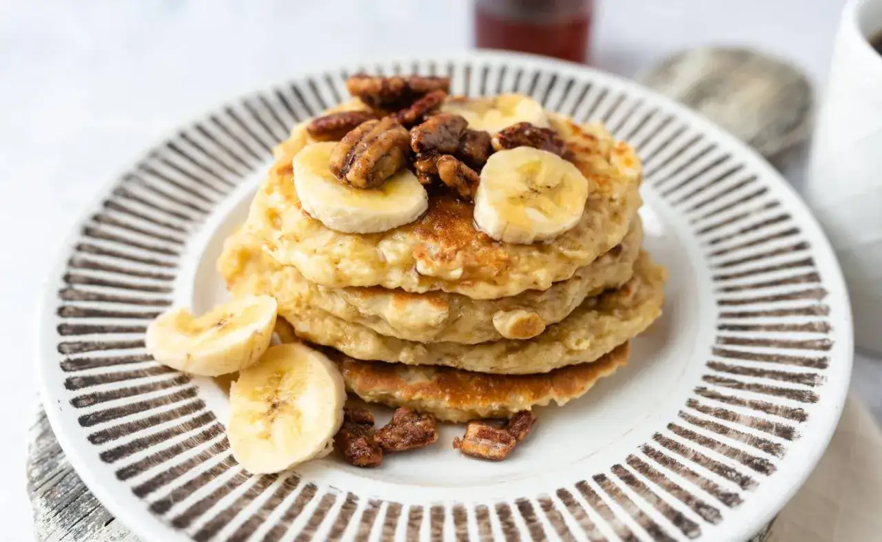 Pile de pancakes muesli aux bananes et noix de p&eacute;can, un petit-d&eacute;jeuner gourmand et sain.
