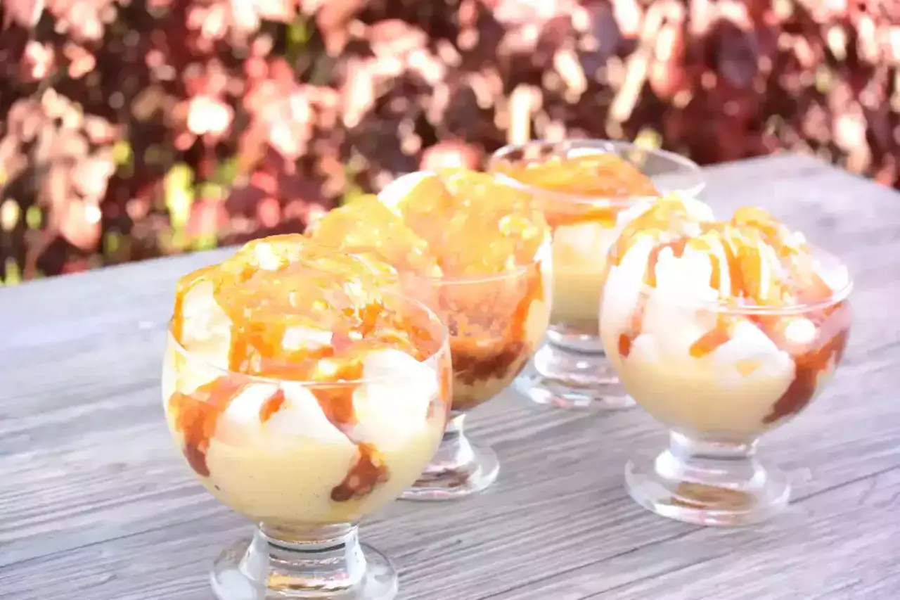 Quatre coupes de verrine remplies d'oeufs &agrave; la neige, napp&eacute;s de caramel.
