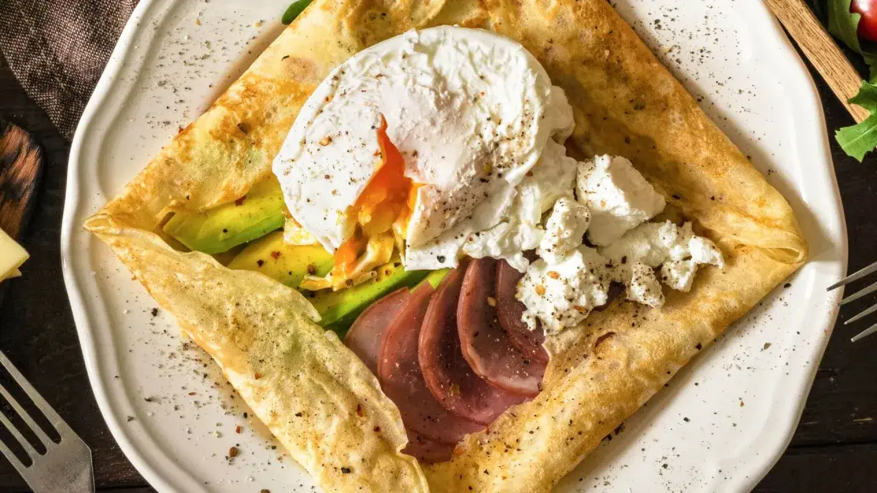 Cr&ecirc;pe au fromage garnie d'un &oelig;uf poch&eacute; coulant, d'avocat, de jambon et de fromage frais. Un d&eacute;lice pour le petit-d&eacute;jeuner.