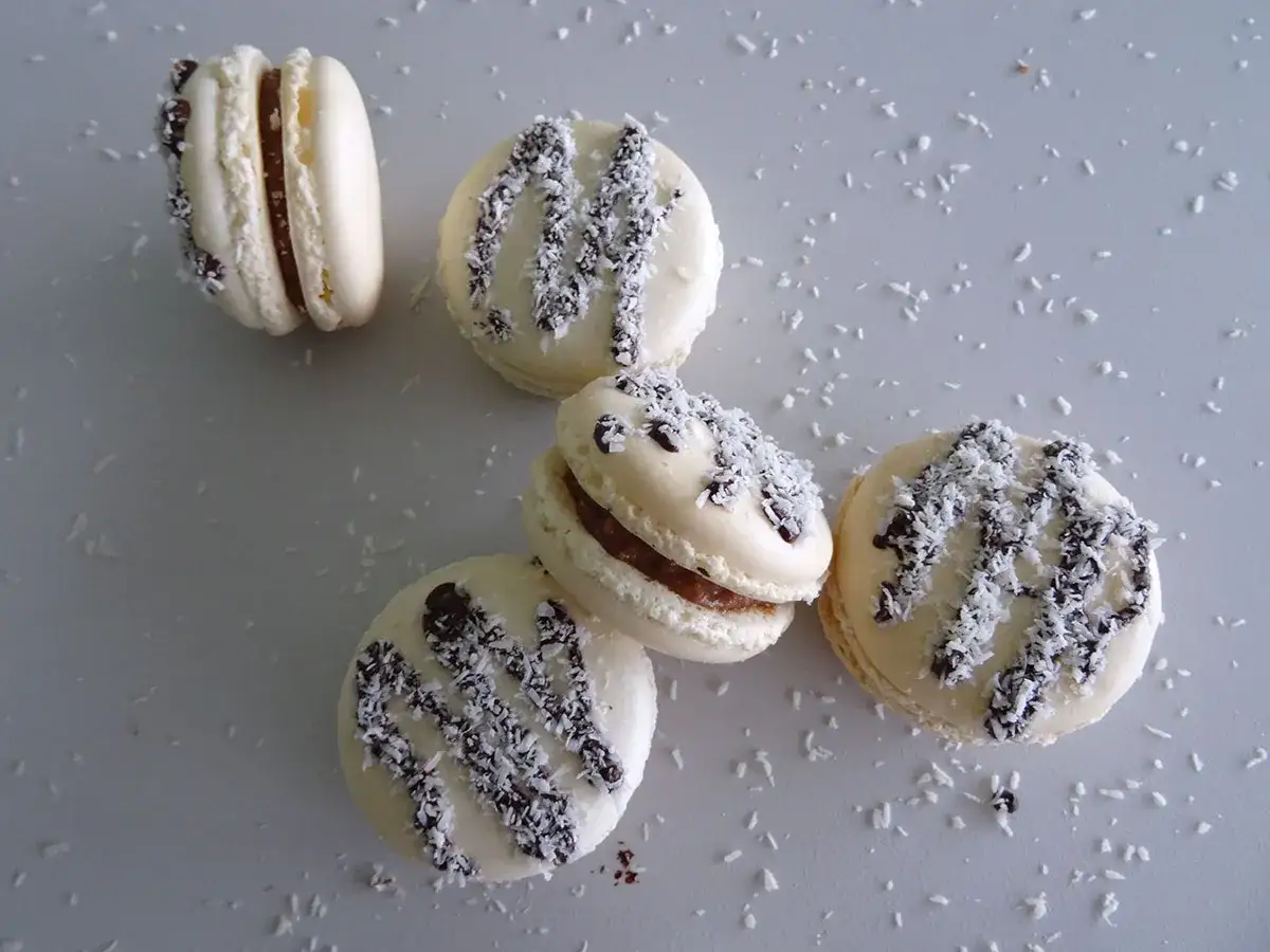 Macarons &agrave; la ganache coco, saupoudr&eacute;s de noix de coco r&acirc;p&eacute;e et de copeaux de chocolat noir.