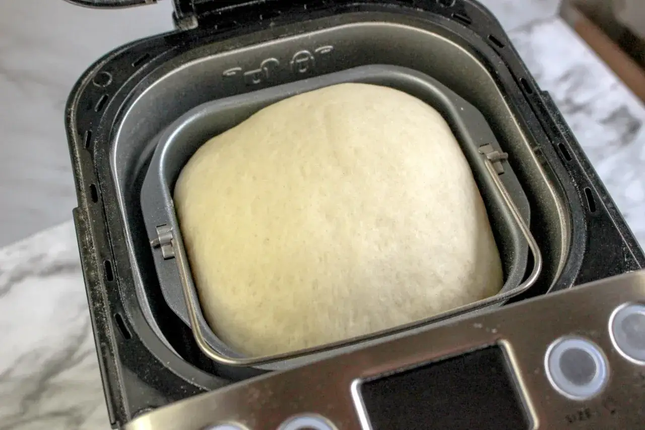 P&acirc;te &agrave; pizza dans une machine &agrave; pain, pr&ecirc;te &agrave; &ecirc;tre cuite pour un d&eacute;lice maison.