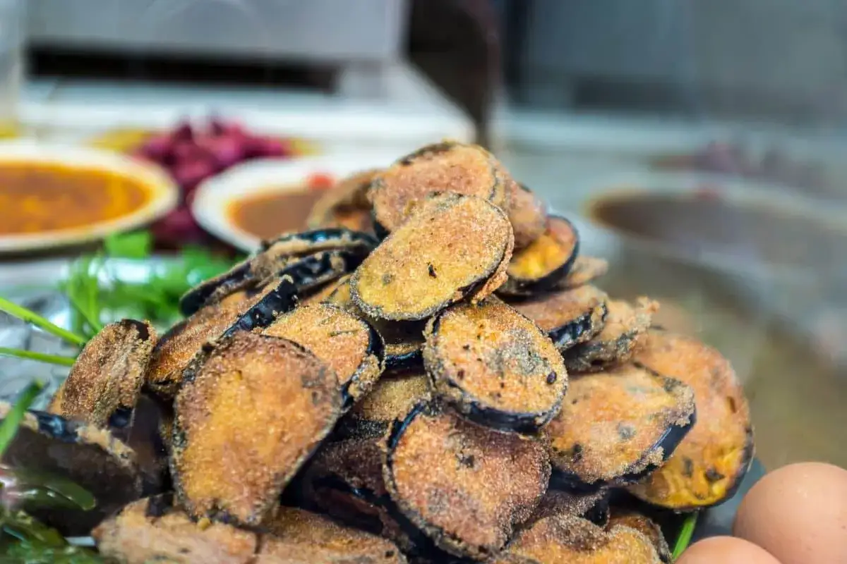 Un tas de beignets d'aubergine dor&eacute;s et croustillants, pr&ecirc;ts &agrave; &ecirc;tre d&eacute;gust&eacute;s.