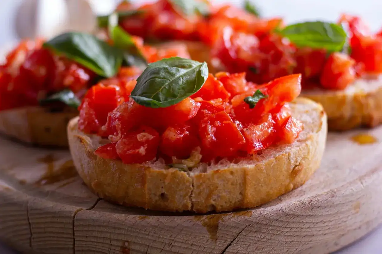 Tranches de pain grillé garnies de tomates fraîches coupées en dés et de basilic. Un délice de pain à la tomate.