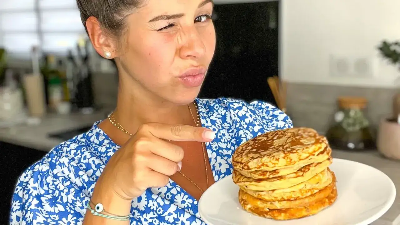 Une femme fait un clin d'&oelig;il en montrant une pile de d&eacute;licieux pancake sans oeuf.
